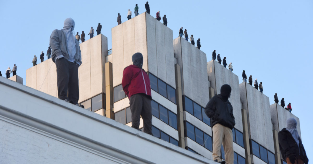 Photo of the Project84 campaign showing statues of 84 men standing on the ledge of ITV's building in London representing the number of male suicides in the UK each week.